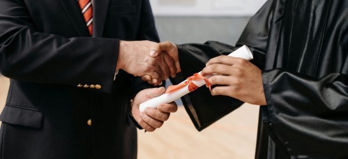 a student recieving a rolled up piece of paper